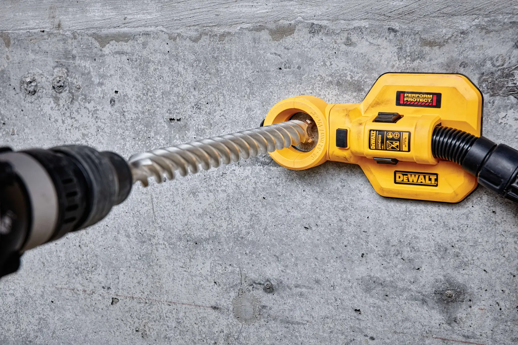 Accesorio DEWALT con taladro para extracción de polvo en una superficie de hormigón.