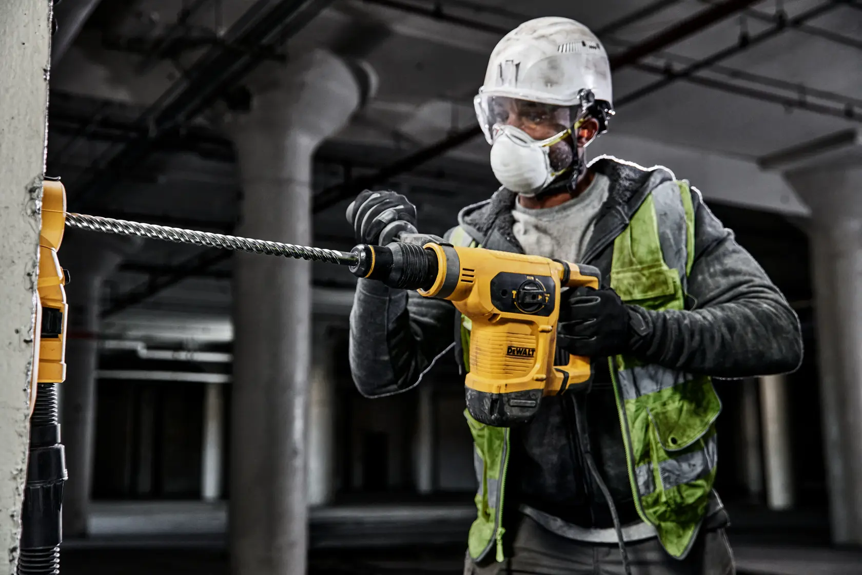 Trabajador usa taladro DEWALT con broca DT60828 en concreto en una construcción.
